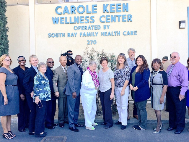 Image of Carole Keen in front of the Carole Keen Wellness Center with friends.